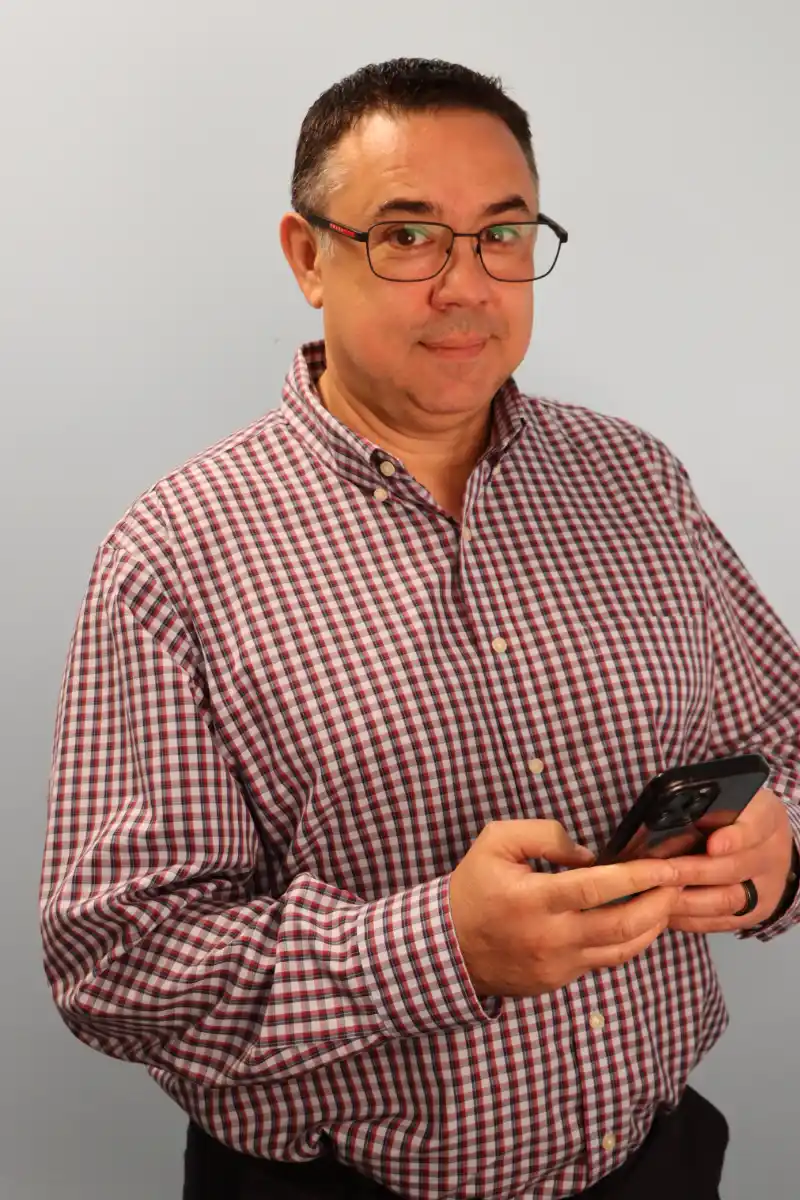 Alex Payne standing on phone in checked shirt